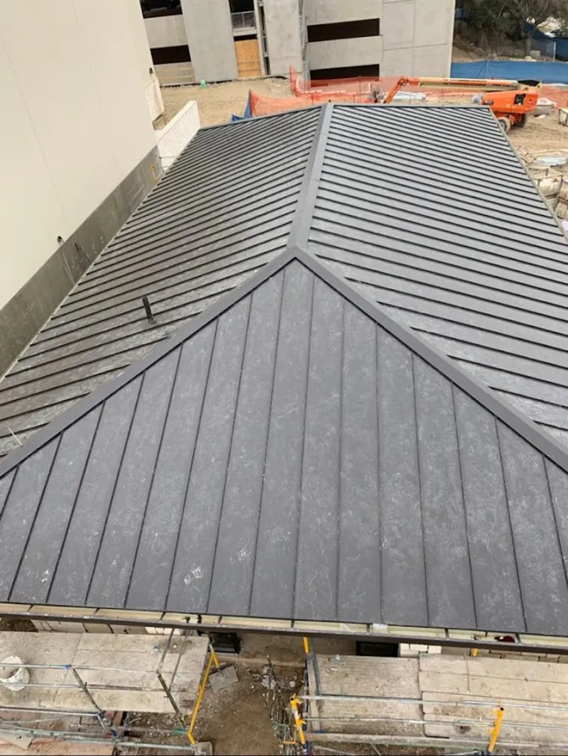 Commercial metal roof construction with crane equipment in Royse City